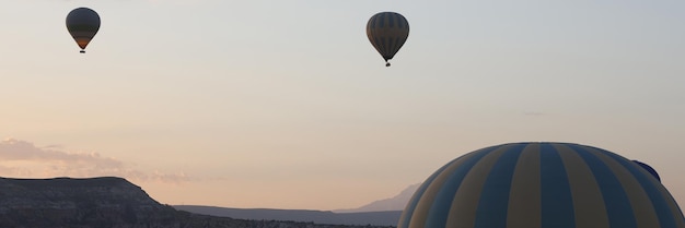 Diverse mongolfiere volano nel viaggio serale nel cielo e nel concetto di avventure estreme