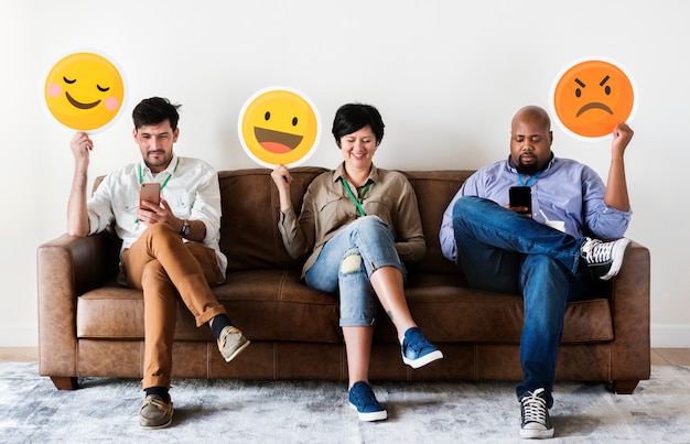 Diverse persone sedute e in possesso di loghi emoji