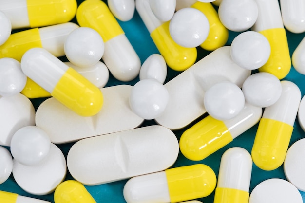 Diverse pillole colorate si chiudono sullo sfondo