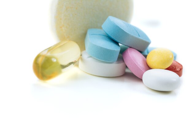 Diverse pillole colorate sullo sfondo bianco del tavolo
