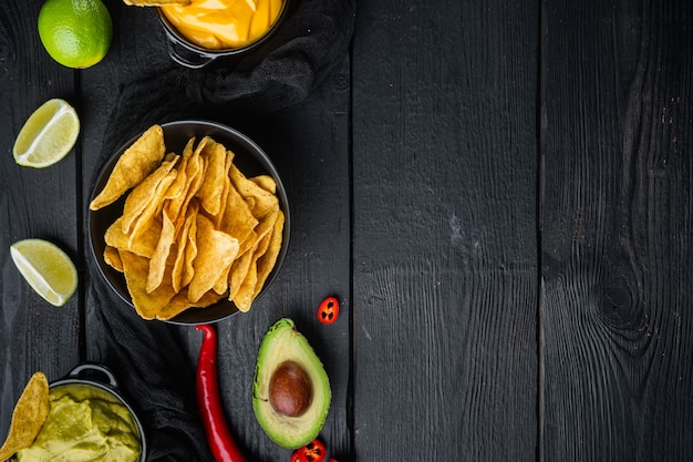 Diverse salse e salse per nachos, sul tavolo di legno nero, vista dall'alto o piatto