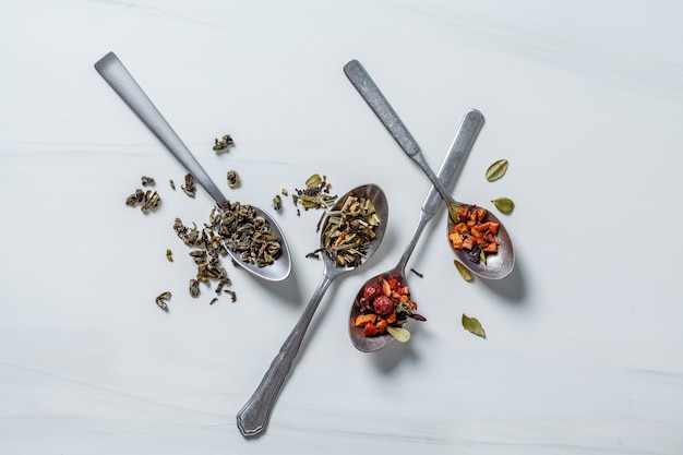 Diverse tisane con miele e spezie su un bianco.