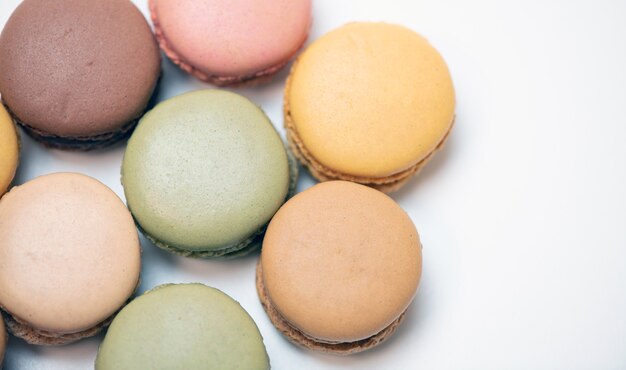 Diverse torte di macaron multicolori su una superficie bianca