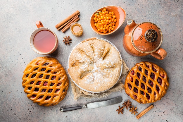 Diverse torte fatte in casa con ingredienti. Crostata torta di frutti di bosco aperta e torta di mele su un tavolo, dall'alto