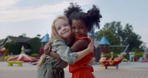 Diversi bambini felici che si abbracciano nel parco giochi per bambini