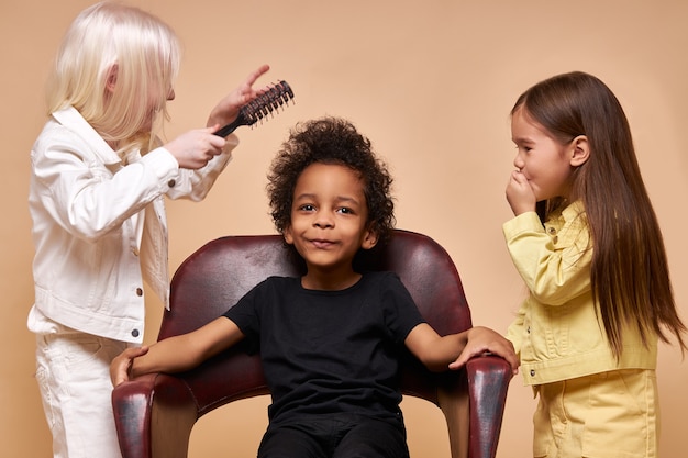 Diversi bambini positivi sorridenti che propongono felici insieme