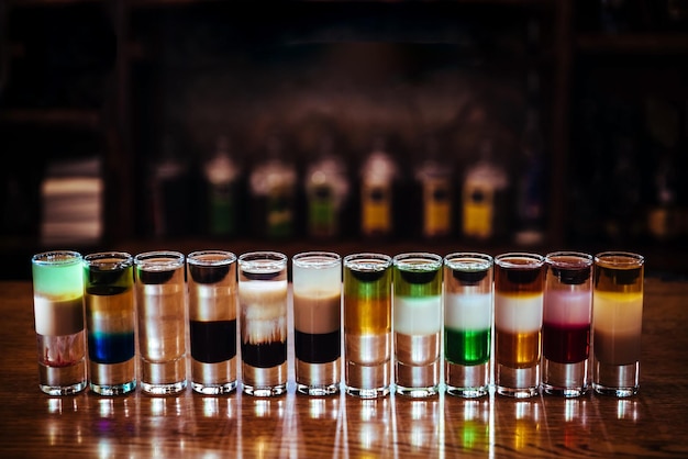 Diversi cocktail alcolici. Short drink multistrato su un tavolo di legno in un bar