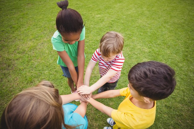 Diversi compagni di classe che uniscono le mani