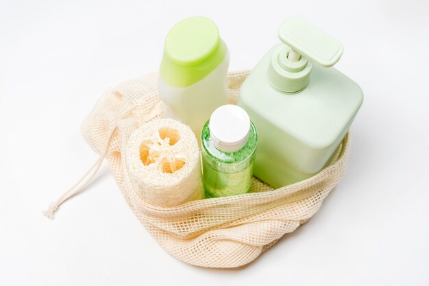 Diversi contenitori per shampoo, balsamo, tonico, sapone liquido in eco bag. Prodotti di bellezza naturali