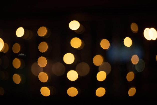 Diversi fili di ghirlande dorate di Natale e Capodanno su sfondo nero. Stile bokeh, messa a fuoco morbida. Sfondo sfocato.