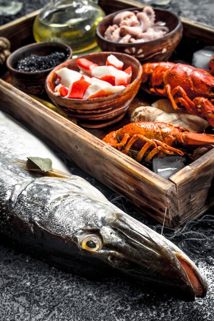 Diversi frutti di mare su un vassoio di legno. Su fondo rustico.