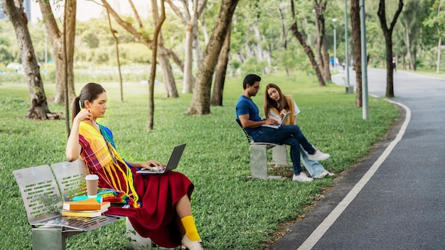 Diversi LGBTQ Gay transessuali Studio all'aperto al Park Young Student all'aperto Working Outside Fiends Studente seduto al parco per lavoro collettivo con notebook e Smart Phone