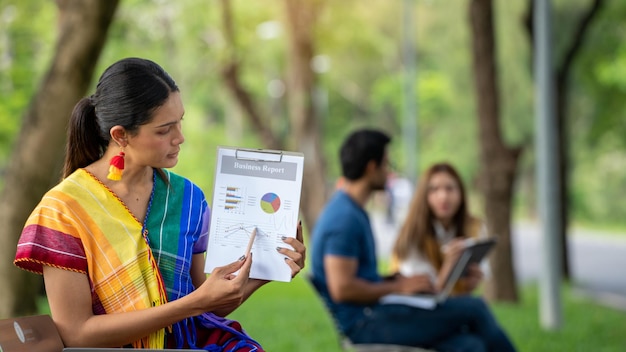 Diversi LGBTQ Gay transessuali Studio all'aperto al Park Young Student all'aperto Working Outside Fiends Studente seduto al parco per lavoro collettivo con notebook e Smart Phone