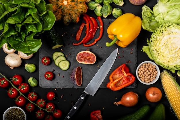 Diversi ortaggi freschi su uno sfondo nero. Cibo vegetariano sano. Vista dall'alto.