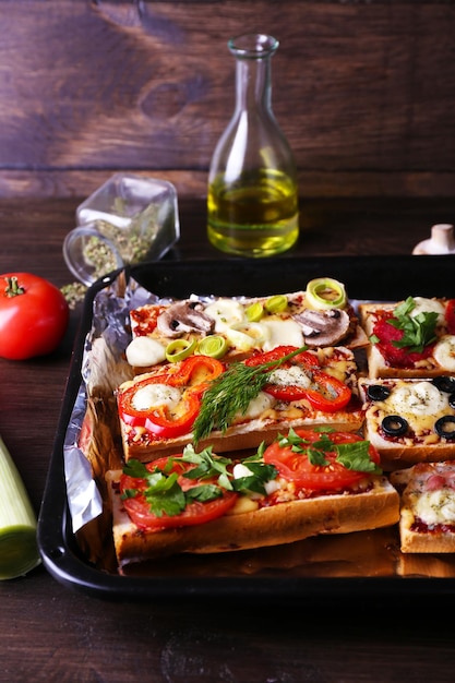 Diversi panini con verdure e formaggio in padella sul tavolo da vicino