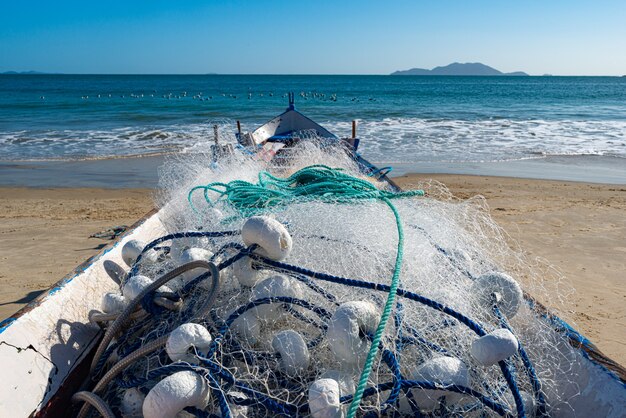 Diversi pescatori che praticano la pesca artigianale con la rete da traino, in una giornata di cielo blu