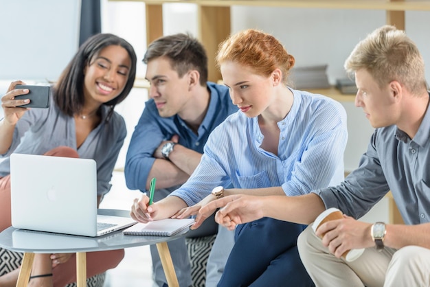 Diversi team aziendali che lavorano su laptop in un ufficio moderno