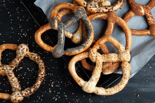 Diversi tipi di bagel al forno con semi su sfondo nero