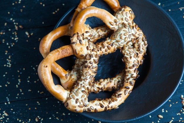 Diversi tipi di bagel al forno con semi su sfondo nero