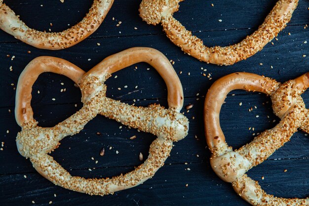 Diversi tipi di bagel al forno con semi su sfondo nero