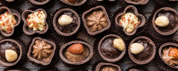 Foto diversi tipi di cioccolatini su tavolo colorato in primo piano top view e flat lay