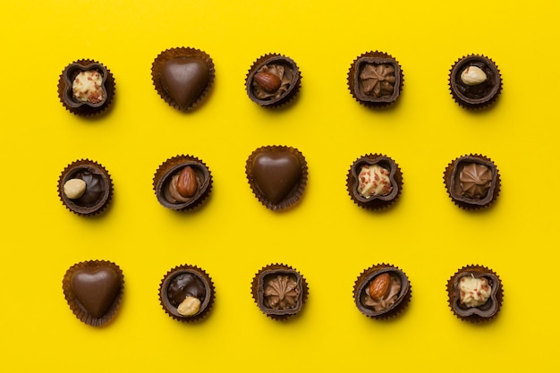 Diversi tipi di cioccolatini sul tavolo colorato in primo piano Top View e Flat Lay