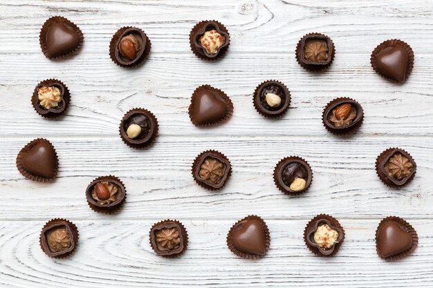 Diversi tipi di cioccolatini sul tavolo colorato in primo piano Top View e Flat Lay