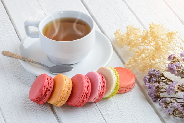 Diversi tipi di colore di amaretti con tazza di tè caldo