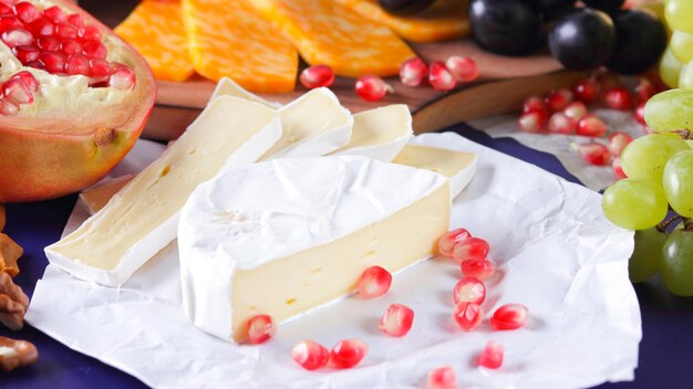 Diversi tipi di formaggio e frutta Camembert e melograno a fette Camembert e uva