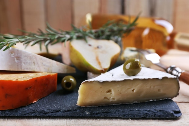 Diversi tipi di formaggio su fondo in legno