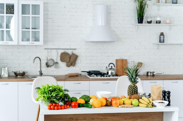 Diversi tipi di frutta e verdura biologica su una moderna cucina di colore bianco. Alimentazione sana.