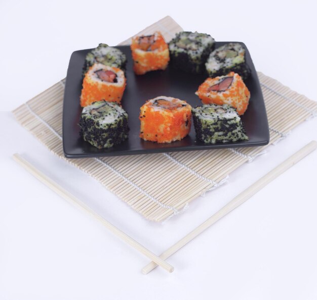 Diversi tipi di maki sushi su un piatto nero