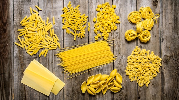 Diversi tipi di pasta secca. Sul tavolo di legno.