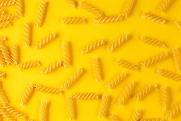 Diversi tipi e forme di pasta secca italiana su sfondo giallo primo piano