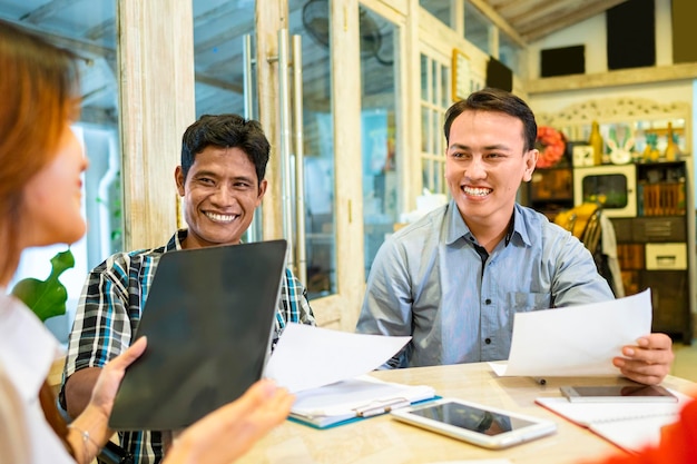Diversità felice Gli uomini d'affari sorridono durante un brainstorming di pianificazione per una riunione di progetto in una startup