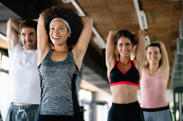 Diversità gruppo di persone che si allenano in palestra. Allenatore e persone in forma sportiva che si esercitano in una lezione di fitness