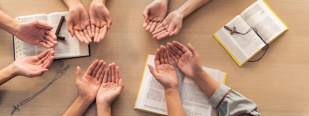 Diversità persone mano pregando fedelmente insieme sul libro della Bibbia Burgeoning