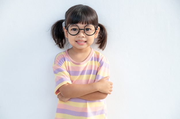 Divertente bambina asiatica con gli occhiali su sfondo bianco