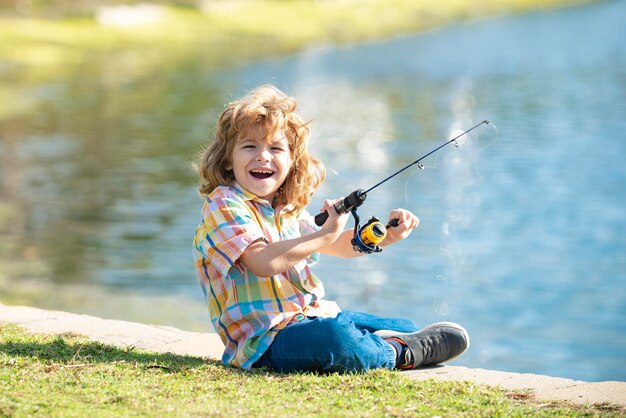 Divertente bambino felice pesca nel fine settimana Un ragazzo pescatore si trova nel lago con una canna da pesca e cattura il pesce