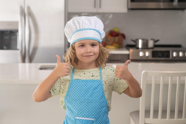 Divertente cucina per bambini Cuoco cuoco bambino divertente che indossa un berretto da cuoco uniforme e un grembiule cibo cucinato in cucina I bambini stanno preparando il cibo cuocere i biscotti in cucina