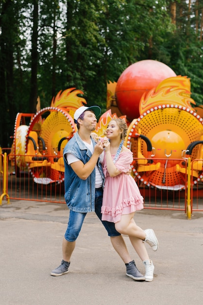 Divertente divertente coppia di un ragazzo e una ragazza di relax in un parco di divertimenti.