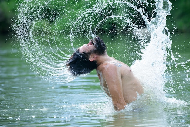 Divertente estate uomo splash goccioline d'acqua nella barba lunga.