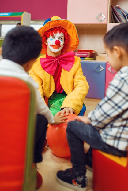 Divertente gioco di clown con bambini allegri insieme.