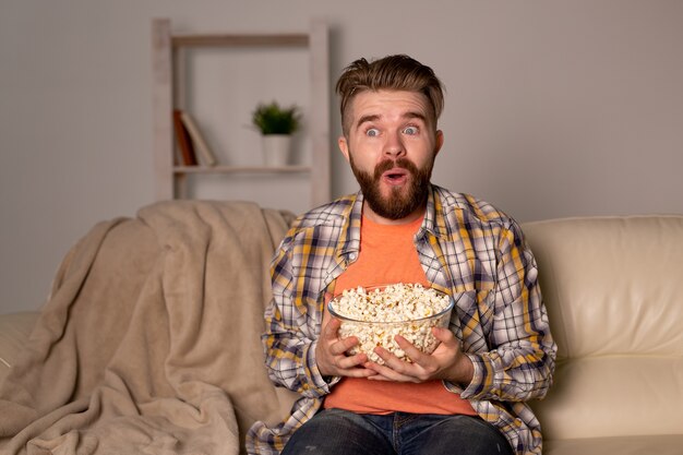 Divertente single sul divano a guardare la tv