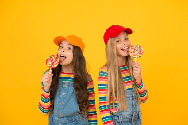 Divertimento e intrattenimento Unisciti alla celebrazione della giornata universale dei bambini Cura dei bambini Alimentazione sana dolcetti Bambini felici Giornata dei bambini felice Celebrazione delle vacanze Ragazze felici che mangiano caramelle lecca-lecca