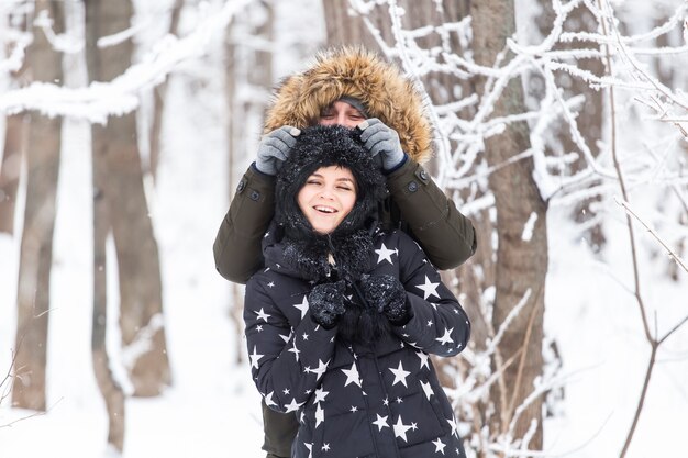 Divertimento, stagione e concetto di svago - la coppia di innamorati gioca a legno d'inverno sulla neve.