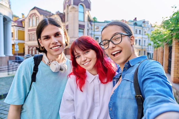 Divertirsi adolescenti felici guardando la fotocamera prendendo selfie