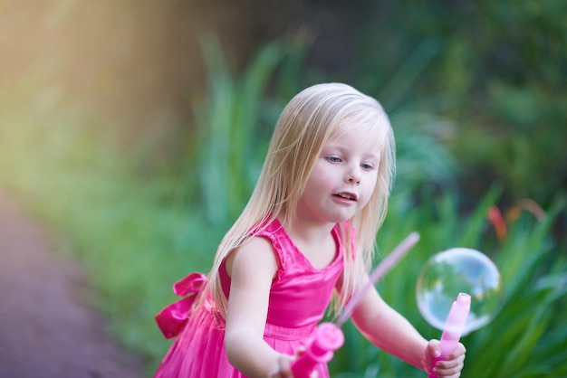 Divertirsi con le bolle Ritagliata foto di una bambina carina che gioca fuori
