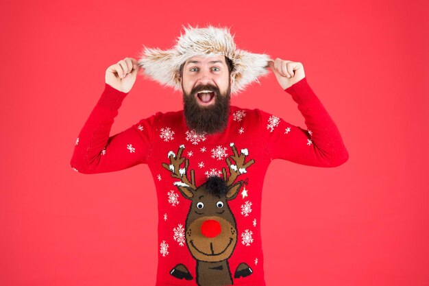 Divertirsi. hipster con la barba nel maglione preferito. accessori di maglieria e pelliccia. Buon anno. buon Natale. moda invernale maschile. provare felicità per le vacanze. indossare vestiti caldi nella stagione fredda.