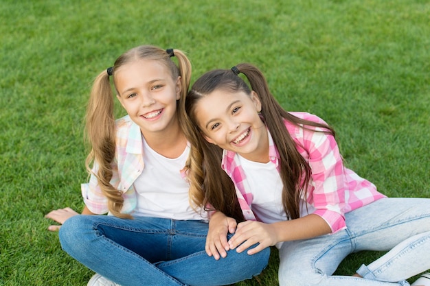 Divertiti. Bambini felici che si rilassano all'aperto. Amici gioiosi. Sorellanza e amicizia. Studentesse allegre in giornata di sole. L'acconciatura della coda di cavallo della ragazza gode delle vacanze estive. Vita felice. Amici sorridenti felici.